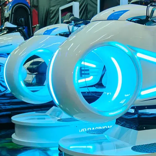 Futuristic white and blue virtual reality arcade machines with circular openings and glowing neon blue lights, lined up in an indoor entertainment center.