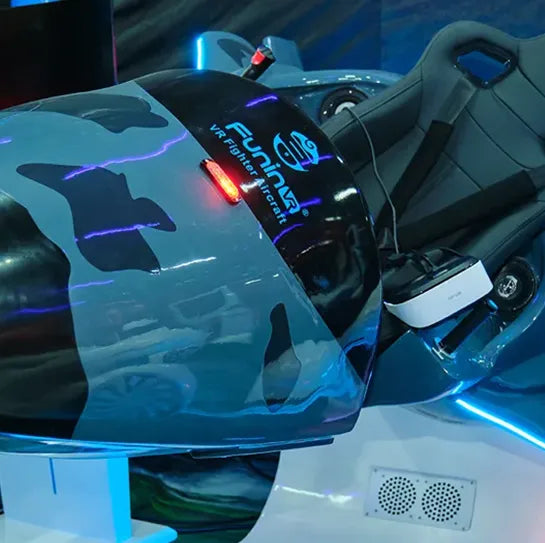 Close-up of a gray and black VR flight simulator ride with the "FuniMation VR Flight Craft" logo, featuring a reclining seat, VR headset, and illuminated blue accents.